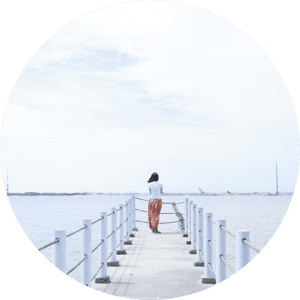 A woman standing on the end of a pier.