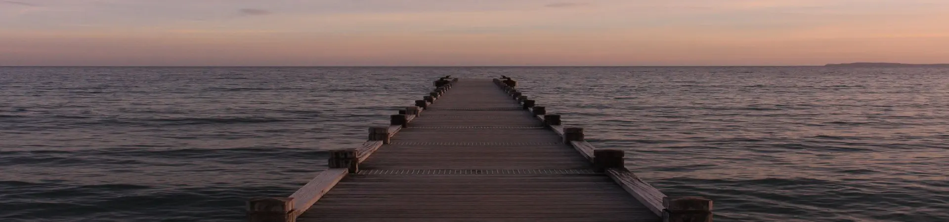 A pier with the ocean in the background.