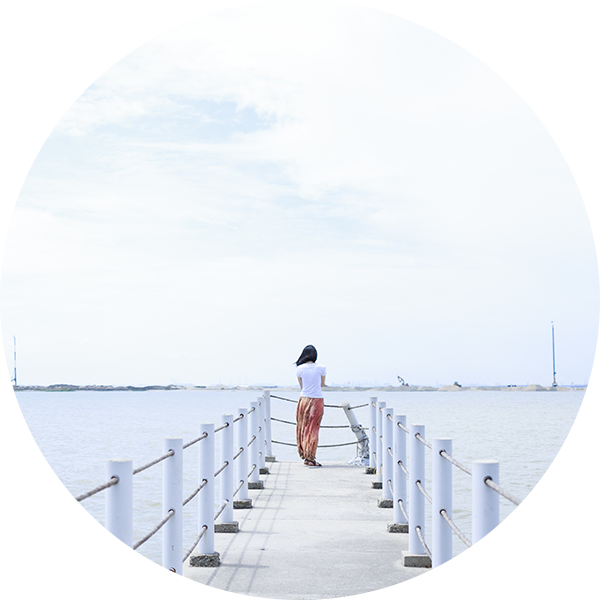 A woman standing on the end of a pier.